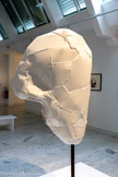 <center></center>Franz WEST
1947-2012, Vienne (Autriche)
Kleine Lemure
2001
Aluminium, peinture blanche
Inv. C.02.14 Achat, 2002.
Kleine Lemure appartient à la série des Lemurenkôpfe (Têtes de Lémures) initiée à l'occasion d'une commande de la ville de Vienne en Autriche qui désirait des sculptures naturalistes pour orner un pont de la ville. Leur nom provient des Lémures, âmes des morts qui, dans l'Antiquité romaine, venaient hanter les vivants.
«J'aime beaucoup boire et parfois, lorsqu'on se réveille le matin, on a mal à la tête et on voit dans les draps toutes sortes de visages étranges; on dit alors que vous voyez des lémures et ils sont très réalistes. Les Lémures proviennent des Saturnales, la fête de Carnaval chez les Romains […] Dans le folklore aussi, il y a des Lémures, mais c'était également un terme qu'on utilisait pour le simple peuple et ils sont à moitié singes, à moitié hommes.»
Dans un travail nourri de psychanalyse autant que de philosophie, Franz West développe une œuvre interrogeant notre rapport au corps, dans ses dimensions sociales et esthétiques, avec un esprit humoristique, anticonformiste et parfois cruel.