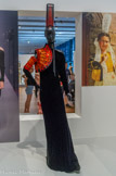 <center>Jean Paul Gaultier.
Robe asymétrique de velours noir, tatouée.</center>Défilé « Paris-Brest », collection haute couture automne-hiver 2015-2016, passage n°53
Robe velours noir tatoué ; épaule de broderie orange et noir sur un laqué fougère noir et gant brodé de cristaux. Coiffe composée d'un grillage polyester, recouvert d'une mousseline noire strassée et rubans de velours noirs. Sabots de velours
Archives Jean Paul Gaultier, Paris
Le créateur rend hommage à la Bretagne en s'inspirant des costumes folkloriques que les Bretons portent aux fest-noz, fêtes reprenant des danses traditionnelles, accompagnées de chants ou de musiques instrumentales.
« Le folklore breton est spécialement riche de broderies et de mélanges de matières, mais aussi d'audace et c'est assez somptueux. » Jean Paul Gaultier.
