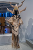 <center>Givenchy par Riccardo Tisci. Robe longue, chapeau et sandales.</center>Collection haute couture printemps-été 2011, passage n°1
Robe : tulle stretch rebrodé, paillettes, tubes de verre, zip ; chapeau : fibre de verre laquée ; sandales : broderies de roues en métal cuivré.
Givenchy Patrimoine, Paris. <br>
Entre douceur et force, cette robe et surtout le casque envoient deux informations différentes qui font se poser des questions. La robe est délicate, elle paraît légère, comme si la personne qui la porte était sans défense. Mais le casque, on dirait celui d'un guerrier prêt à se battre.
Les formes du casque comme celles de la robe sont pointues et font penser à des couteaux ou des haches. Au contraire, le blanc de la tenue amène le calme et la paix.