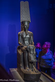 Amon protégeant Toutankhamon.
Diorite.
Règne de Toutankhamon 1336-1326 av. J.C. Musée du Louvre.<br>
C'est te visage intact d'Amon qui fait tout le prix de cette statue du règne de Toutankhamon. Selon les conventions égyptiennes, les traits du dieu sont ceux du souverain, car le roi est l’émanation terrestre du pouvoir divin. Ainsi l’on reconnaît le visage de Toutânkhamon dans celui d'Amon.