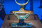 Appui-tête en faïence égyptienne bleu foncé avec inscriptions.
Le voyage quotidien de Rê dans le ciel représentait la résurrection. Le bleu, couleur du ciel, symbolisait la renaissance magique qui devait se produire dans l’au-delà.
Faïence égyptienne, feuille d'or.<br>
Appui-tête en verre turquoise cerclé d’or avec inscriptions.
En étudiant et en adaptant les techniques venues du Proche- Orient, les verriers du Nouvel Empire devinrent des experts dans la pratique de leur art. Le nom de Toutânkhamon est inscrit sur les deux appuis-tête.
Verre, feuille d'or