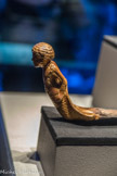 Figurine en bois doré d’un prisonnier sur une pièce de bois courbée en forme de pointe de dague.
Les bras entravés de chaque côté, le prisonnier n’a aucun moyen de s'échapper. Cet élément d'un char célèbre le triomphe de Toutânkhamon sur ses ennemis.
Bois, gesso, feuille d'or