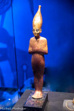 Statuette en bois doré de Tata sur socle avec inscriptions
Tata, symbole de fertilité et donc, de la renaissance et de la résurrection dans l’au-delà, porte la couronne blanche de la Haute-Égypte. Lu aussi était un «fieu de protection dans le inonde des morts.
Bois, gesso, feuille d’or, résine noire, bronze, obsidienne (yeux)
