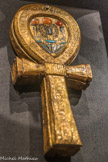 Boitier à miroir en forme d’ânkh en bois doré incrusté de verre bleu et de cornaline
Les miroirs symbolisaient la résurrection et la vie éternelle. Les croix ansées, ou ânkh, représenta la vie. Ici, le disque solaire et des scarabées en cornaline encadrent le nom de Toutânkhamon.
Bois, feuille d'or, verre, cornaline.