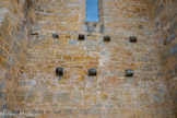 <center>Abbaye de Beaulieu-en-Rouergue  </center>Le cloître. Quelques corbeaux, pierres en saillie sur le mur de l’église, montrent que ses galeries étaient couvertes d’une charpente en bois.