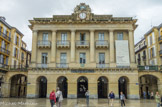 <center>San Sebastian</center>Place de la Constitution. La Plaza de la Constitucion est le coeur de la ville, elle est entourée d'arcades. C'est là que se tiennent les principales fêtes et manifestations. Cette place a été créée en 1689, elle s'appelait alors Place Neuve, elle avait la même configuration que la place actuelle, l'Hôtel de Ville était un bâtiment de style Baroque. En 1813, une armée anglo-portuguaise s'est emparée de la ville de San Sébastian et y a provoqué de grandes destructions, en particulier sur cette place dont la reconstruction a commencé en 1817. L'Hôtel de Ville (Casa Consistorial ou Ayuntamiento) a été reconstruit de 1828 à 1832 en style néo-classique, c'est le bâtiment qui est maintenant affecté à la bibliothèque municipale.