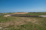 Le Fâ Barzan. <br> La ville portuaire antique du Fâ, en activité du début de notre ère au IIIe siècle ap. J.-C., dort aujourd'hui sous des champs de céréales et de vignes dans un paysage de collines douces baignées par la Gironde. A l'exception du podium du temple circulaire, les traces de cette occupation sont presque invisibles, sauf pour un œil averti qui reconnaîtra la forme semi-circulaire si caractéristique d'un théâtre dans la colline de la Garde au sud-est.
Cette cité fut découverte grâce aux photographies aériennes de l'archéologue prospecteur Jacques Dassié durant les exceptionnelles sécheresses des étés 1975 et 1976. Il a été le premier à déceler le plan de la ville dans les céréales. Vingt ans plus tard, sous l'impulsion de l'ASSA-Barzan, la recherche s'est mise en place. Aujourd'hui, trois équipes scientifiques contribuent à la connaissance du site et, grâce à l'exploration archéologique, décryptent les premiers éléments de son histoire.
Du 1er siècle jusqu'au début du IIIe siècle ap. J.-C., le contexte économique favorable de la Paix Romaine peut expliquer le développement de la ville. En outre, la proximité de MEDIOLANUM SANTONUM (Saintes), civitas (capitale de province), et de voies ralliant BURDIGALA (Bordeaux), est vraisemblablement à l'origine de l'essor des échanges économiques et de l'embellissement de la ville. Il apparaît aujourd'hui évident que cette cité était admirablement située pour constituer un port ouvert sur l'Atlantique par l'estuaire de la Gironde.
