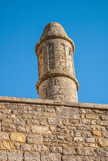 <center>Abbaye de Nouaillé-Maupertuis. </center> Près du clocher-porche, émerge du toit une cheminée cylindrique du XIIe siècle, comparable aux cheminées de la cuisine de Fontevraud.