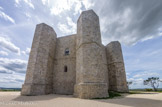 <center>Castel del Monte.</center>Toutes les parois présentent deux fenêtres : une à simple baie correspondant au rez-de-chaussée, et une à deux arcs au deuxième étage, pas toujours verticalement alignées. Cette règle n'est pas respectée sur les faces occidentales et orientales, où sont percées les deux portes, et qui n'ont pas de fenêtre du rez-de-chaussée, et la face nord, qui présente une fenêtre à trois arcs au deuxième niveau. De plus, des meurtrières dans les parois des tourelles donnent de la lumière aux escaliers en colimaçon aménagés à l'intérieur.
D'un point de vue structurel, il est important de noter que les murs du bâtiment principal, entre les tourelles, émergent directement du sol, tandis que les tourelles présentent un soubassement, dont le sommet est mis en valeur par une corniche de style gothique.