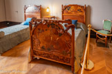 <center>Le château Laurens</center>La chambre de sa soeur, Marguerite Laurens. Les éléments sont en noyer sculpté de motifs floraux (de type nelumbos ou fleurs de lotus en boutons), complétés par des panneaux en cuir peint et doré figurant des jeunes filles cueillant des fleurs, ainsi que des parties en cuivre découpées et posées en applique au chevet des lits.