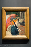 La femme à l'ombrelle. Louis Anqueti. Huile sur toile, 1891.
Encouragé par Emile Bernard» Anquetin développe une technique picturale. Dès 1887, à Asnières, ils font des recherches expérimentales •(aboutissent à une nouvelle manière de peindre. Le critique Edouard Dujardin (1861-1949) la remarque et l'analyse dans la Revue Indépendante : « Le travail du peintre sera quelque chose comme une peinture par compartiments» analogue au cloisonné» et sa technique consistera en une sorte de cloisonnisme, le dessin affirmant la couleur et la couleur affirmant le dessin». C'est ainsi que nait le cloisonnisme. Ce courant méconnu de la fin du XIXe siècle a une vie propre très brève» sans doute parce qu'il influence l'École de Pont-Aven qui le diffuse. Le cloisonnisme devient alors une des bases du synthétisme.
La femme à l’ombrelle est caractéristique : les aplats de couleurs vives sont délimités par de larges traits noirs : parapluie rouge» robe bleue» visage et main roses» cheveux roux» kiosque gris» arbres verts» silhouette d'homme noire» bitume gris. Le cerne noir donne l'illusion de la perspective.