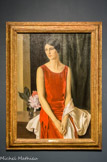 Portrait de Mary Louise McBride (Mme Homer Saint-Gaudens). Louis Buisseret (1888-1956). Huile sur toile, 1929.
Louis Buisseret se livre généralement à des représentations limitées à deux ou trois personnages, dans lesquelles le mouvement s'annihile complètement devant le rendu de l'intériorité. En 1911, le peintre obtient le prix de Rome qui lui permet de se rendre en Italie. Il est alors fortement impressionné par la peinture de Piero della Francesca et s'attache à atteindre « l'Absolue harmonie » qu'il décèle dans l'œuvre du peintre italien. L'ordonnance équilibrée de la composition et sa sobriété, qu'il travaille particulièrement dans les portraits, contribuent à créer dans ses toiles une atmosphère grave et dépouillée, Buisseret parle lui-même de « l'immatérielle poésie qui enveloppe les choses ». Le peintre opère dans les années 1920-1930 à un retour au réel, ici encore empreint de la période Art Déco, au travers de la coiffure du personnage.