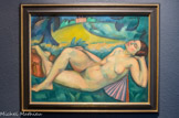 La mélancolie. ANDRÉ LHOTE (1885-1962). Huile sur papier marouflé, ca. 1912
Elève à l’école des Beaux-Arts de Bordeaux à partir de 1898, André Lhote découvre l'impressionnisme au travers des œuvres d'Henri Martin conservées au musée de Bordeaux. Une relation amicale avec le brocanteur Pascal Désir Maisonneuve, lui fait découvrir en 1906 l'art nègre. En 1907, il expose quatre toiles au Salon des Indépendants dans lequel il sera admis en tant que membre sous la présidence de Paul Signac et découvre en 1910 à l'occasion d'une rétrospective au Salon d'Automne, l'œuvre de Cézanne. En 1911, il quitte définitivement sa ville natale pour s'Installer à Paris et fait partie à partir de 1912 du Groupe de la Section d'Or. Il pratique depuis 1910 un cubisme qui concilie modernité et tradition.
La Mélancolie est à situer dans les années 1912. Un peu plus tôt, en 1910 dans une œuvre intitulée Bacchante, Lhote s'est déjà essayé au nu féminin dans un paysage, en y associant une nature morte dans laquelle on retrouve comme dans notre tableau, un éventail. Les couleurs pures, héritées du fauvisme y tranchent avec les tons cézanniens. Le corps de la jeune femme y est ample, presque monumental. Un passage dans la section de sculpture décorative à l’école des Beaux-Arts de Bordeaux, a en effet fortement contribué selon Bernard Dorival à donner au peintre « ses exigences de solidité, de précision, voire de dureté dans l'établissement de la forme.»