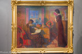 La lecture, Intimité. LÉON DE SMET (1881-1966). Huile sur toile, 1913
Les deux œuvres présentées à Lodève datent de la période où Léon de Smet réside sur les rives de la Lys. Il y reste jusqu'en 1913. Le peintre travaille dans la mouvance du luminisme que Claus instaure dans la région gantoise en observant et reproduisant la lumière du jour. Cet impressionnisme tardif connu sous le nom de luminisme y est particulièrement développé.
Dans ses scènes d'intérieur, de Smet montre le meilleur de son art. À l'apogée de sa période pointilliste, il peint La lecture-Intimité. Cette technique le rapproche de Théo Van Rysselberghe (1862-1926). Les couleurs féeriques, le raffinement, la douceur chromatique, les dimensions colossales confèrent à l'œuvre une atmosphère particulière. Une chaleureuse lumière baigne la scène.
