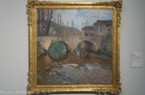 Le pont sur le Vert. HENRI MARTIN, (1860-1943). Huile sur toile
En 1899, Henri Martin achète Marquayrol. Ce domaine lotois qui surplombe Labastide-du-Vert fut un ancrage méridional définitif. Dès lors, la maison, sa pergola, son jardin peuplé de cyprès qui rappellent l'Italie, le bassin circulaire, le village, son église, le Vert et les peupliers qui le bordent, son pont, furent des motifs favoris. Il multiplia avec amour leurs portraitures. Ils devinrent matière à décliner à l'envie des harmonies lumineuses et colorées variant au cours des heures et des saisons.
Comme à son habitude Henri Martin architecture, sans qu'il n'y paraisse, le sujet qui l'inspire. La touche dissociée variée très libre, virtuose sans systématisme, plaiderait pour une datation des années de maturité du peintre.