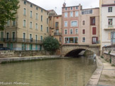 <center> Pont des Marchands</center> Le pont romain est très bien conservé mais est de nos jour difficilement perceptible car ses six ou sept arches et rampes d’accès sont noyées dans le bâti environnant, servant de caves aux maisons qui surmontent le pont depuis l’époque médiévale et qui ont transformé la chaussée en rue continue, ne donnant plus de visibilité sur le cours d’eau.