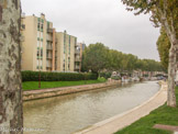 <center>Canal de la Robine.</center> Le canal mesure 32 km de long et commence, en son point le plus haut, au bord de l'Aude et se dirige vers Narbonne. Son point de départ est l'écluse de garde de Moussoulens, qui protège Narbonne en cas de crue. Le canal passe sous le pont des Marchands à Narbonne qui est l'un des rares ponts habités de France. Il longe ensuite les étangs de Bages et de Sigean et la réserve naturelle de l'Île-Sainte-Lucie. Il termine sa course dans la mer Méditerranée au port de commerce de Port-la-Nouvelle. Six écluses jalonnent son parcours rachetant une dénivellation de 8,3 m. Il est alimenté par la prise d'eau de Moussoulens sur l'Aude. Le chemin de halage est aménagé en voie verte du centre de Narbonne jusqu'à Port-la-Nouvelle