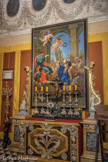 Villa del Principe. Palais d'Andrea Doria.<br> La Chapelle.Le rétable a été réalisé au début du dix-huitième par Giovanni Battista Gaulli, dit le “Baciccio”. Face au retable, on voit un crucifix du dix-septième, d’un mètre de haut, réalisé en bois de prix. Il s’agit d’un ouvrage remarquable qui presque assurément serait originaire de la Villa : une rare version des grand Christ “mori” des confréries génoises à usage privé, qui doivent leur nom au fait que le bois de couleur sombre utilisé était laissé en vue. Ay-dessus, noter une série de seize ovales peints en noir-bleu à imitation de l’ardoise, entourés par de riches guirlandes de fruits.