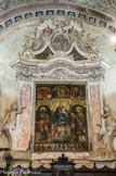<center>Apricale.</center> Rétable de 1544 par Agostino Casanova. La Vierge est entourée , à gauche par Saint Barthélémy portant la palme du martyr, à droite par Saint Laurent reconnaissable par le gril, instrument de son supplice. En haut, l'annonciation encadrant une mise au tombeau. La pradelle représente le Christ entouré des apôtres.