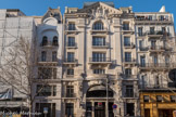 Crédit foncier d'Algérie et de Tunisie. 15-17 La Canebière. Ponsard P, architecte 1918.
La Première Guerre mondiale fait de Marseille une place financière, la France prenant appui sur ses colonies pour les produits et les hommes. On construit donc des banques dont celle-ci fait partie. Le gabarit de l'immeuble profite du règlement de 1904 pour gagner des volumes en retrait sur l'alignement. La façade use des registres classiques avec un soubassement sur deux niveaux centré sur une entrée en serlienne. Le corps de façade prend de l'ampleur avec un ordre colossal néo dorique, couvert d'un fronton à base interrompue qui loge une arche centrale.