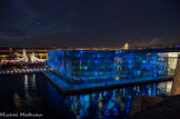 <center></center><center>Le MuCEM.</center>L’architecte a imaginé le futur musée dans un matériau inspiré par « le paysage minéral de Marseille et les pierres du Fort Saint-Jean » : le béton. Pas un béton ordinaire, un béton « exceptionnel, à la pointe des dernières recherches scientifiques » qui lui permet de faire… de la dentelle ! Sur le môle va donc s’élever un cube minéral bordé de douves, enserré par une résille de béton fibré et des façades brise-vent qui laisseront passer la lumière, l’air et les odeurs d’iode.
