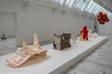 Dans ce cortège de sculptures se lit l’intérêt d’Anita Molinero pour le mou, l’informe, l’hybride. Elle étire tellement les matériaux en les chauffant qu’ils s'en trouvent déformés et monstrueux. Les cinq œuvres sont ici présentées dans un dispositif évoquant les Freak show, ces stands de foire nés au XIXe siècle aux États-Unis qui faisait commerce de l’exhibition d’êtres humains qualifiés de « monstres humains » en raison de leurs malformations physiques hors norme. Pour l’œuvre Sans titre (Oyonnax), Anita Molinero s’est installée le temps d’une journée dans une usine de fabrication plastique pour y déformer elle-même les plots ou séparateurs de voie encore chauds, tout droits sortis des machines, « à la sortie du tube ». Ces objets qui marquent de manière artificielle et programmée l’espace public, portent la toxicité du plastique, en partie fondu par la chaleur d’une flamme, et oscillent entre banalité et démesure esthétique. Courtesy de l’artiste et de la Galerie Christophe Gaillard, Paris