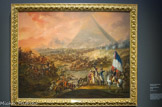 <center>Bataille des Pyramides, 21 juillet 1798</center>François Louis Joseph Watteau. Vers 1800. Huile sur toile. Musée des Beaux-Arts de Valenciennes
Lors de la bataille des Pyramides (21 juillet 1798), Bonaparte et son armée remportent la victoire contre les mamelouks. Le peintre nous donne une vision de l'événement qui glorifie les actions de l'armée française d'Orient. Cette victoire marque profondément l'imaginaire français et européen. Avec l'expédition d'Egypte (juillet 1798 - août 1801), Bonaparte poursuit un but militaire, couper la route de l'Inde aux Anglais, et un projet de civilisation réformer et étudier l'Egypte. Mais le peuple du Caire accepte difficilement ces « missionnaires armés » et se révolte. La répression envers la population sera brutale. L'expédition est finalement un échec militaire, Bonaparte doit quitter l'Egypte, mais elle devient une légende à l'avantage de Bonaparte sous le pinceau de peintres qui glorifient l'histoire nationale.