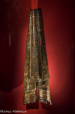 <center>Retombée de paludamentum (manteau impérial).</center>Volubilis, Maroc. Début du IIIe siècle apr. J.-C. 
Ce fragment de manteau impérial est remarquable par ses applications de patines (or, argent, laiton) destinées à produire une polychromie riche et harmonieuse. I1 est décoré de deux captifs qui portent des braies et le manteau gaulois (sagum), costume caractéristique des Barbares. On peut ainsi identifier un Parthe et un Breton.