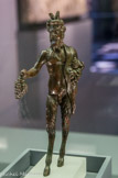 <center>Statuette de satyre ou faune</center>Empire romain, Ier siècle apr. J.-C. Bronze
Collection Fondation Gandur pour l'Art, Genève <br>
Dionysos est lié aux orgies du vin et sa représentation est souvent accompagnée du cortège dionysiaque : silènes et satyres, ces êtres hybrides au corps humain comportant des caractéristiques animales, appartiennent au monde sauvage, tout en maîtrisant la technique de la fabrication du vin et la musique. Les satyres sont souvent représentés avec des sabots, des queues de bouc, des oreilles pointues.