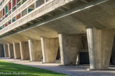 <center></center><center>La Cité Radieuse.</center>  Le bâtiment repose sur des pilotis qui, de part et d'autre de l'entrée, forment deux vastes espaces de portiques, ouverts sur le hall et le parc.
