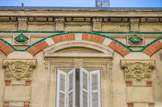 <center>25 rue Fargès</center>Les frontons curvilignessont surmontés par des arcs de briques et une ligne de céramique bleu vert associée à des bobèches.