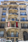<center>310 rue Paradis</center>Mouren P, architecte, 1911. Cet immeuble, qui donne à la fois sur la rue Paradis et la place Delibes, marque la fin de l'haussmannisme à Marseille. Aux bow-windows ouvrant sur la place répondent les loggias de la rue, habituellement placées sur cour. Les divisions de cette large ouverture en creux lui donnent plus de verticalité. Les seuls décors sont les bossages, pour certains vermiculés, et un couronnement rythmé de pilastres toscans.