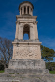 <center>Le mausolée des Julii.</center>Face Est : une bataille sans référence mythologique claire, avec un cavalier en mauvaise posture au sein d’une mêlée, protégé par le bouclier du personnage central. On remarque à gauche de la scène un groupe de personnages sans rapport apparent avec la bataille : ils sont en habits civils, un jeune garçon lit un document. On interprète ce groupe comme la famille du défunt, recevant son attestation de citoyenneté romaine. Dans cette interprétation, la bataille illustrerait une action d’éclat du défunt, au centre du bas-relief, combattant dans l’armée romaine et gagnant la citoyenneté romaine en récompense de cet exploit.