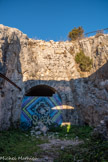 <center>Le Mont Caume Est</center>Porte d'entrée (murée) du souterrain-caverne au fond de la courette encaissée de l'ancienne porte. C'est une grande arcade de gabarit charretier à arc plein-cintre. Il fallait passer par cette arcade d'entrée et par le souterrain pour desservir les batteries.