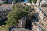 <center>Le Mont Caume Ouest</center>Ruines du baraquement crénelé hors enceinte en contrebas du chemin. L'espace intermédiaire entre mur de façade et mur de soutènement du chemin, large de 2m était une sorte de couloir de distribution à ciel ouvert plus qu'une cour encaissée, desservi par un escalier droit maçonné.