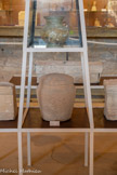<center>Musée de Tauroetum</center>Urne en pierre contenant l'urne en verre placée au-dessus. A côté, deux petits autels votifs.
