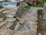 <center>Musée de Tauroetum</center>Cette canalisation voûtée qui longe la terrasse, en partie comblée, et la reprise en coude, visible actuellement pour détourner le flux lors d’une phase postérieure, alimentait un bassin extérieur. De très nombreux vestiges de collecteurs, canalisations et points de stockage d’eau ont été recensés sur le site et non loin, y compris le bassin au premier plan. La confusion entre amenées et évacuations d’eau est possible dans l’analyse de ces réseaux qui ont été modifiés au cours de presque quatre siècles d’utilisation du site.