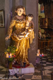 <center>Cathédrale Notre-Dame-de-la-Seds </center>Statue de Notre Dame de la Paix. A l'origine, jusqu’en décembre 1921, elle se trouvait au centre du monument de l’archiconfrérie, datant de 1660, ex-voto de reconnaissance de nos aïeux pour la préservation de la peste de 1657 et la paix des Pyrénée et qui était accroché à la place du tableau ovale représentant Sainte Hélène et son fils Constantin. La satue était entourée de deux anges debout et d’un ange agenouillé à chaque extrémité de l’entablement. Ceci explique le traitement assez grossier de la part du sculpteur Languenau (mort à Toulon en 1718, ayant travaillé avec Pierre Puget à la décoration de la chapelle du Corpus Domini), puisque elle doit être vue de loin et en contre plongée. Le bras droit de l’Enfant Jésus a été arraché sous la Terreur, dans la main gauche, il tient un globe terrestre.