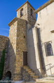 <center>Vacqueyras </center> L'église primitive de Vacqueyras fut édifiée au XIIème siècle. Elle se composait d'une chapelle orientée est-ouest et d'une tour supportant le clocher. L'abside encore visible de cette chapelle romane se reconnaît aisément et se trouve à droite de l'entrée. La tour, de forme carrée, fait corps avec les remparts. Elle était probablement dotée d'une fonction de surveillance indispensable durant les temps troublés.