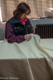 <center>La manufacture Brun de Vian-Tiran.</center>On répare un fil de chaîne cassé à l'aide d'une grosse aiguille.